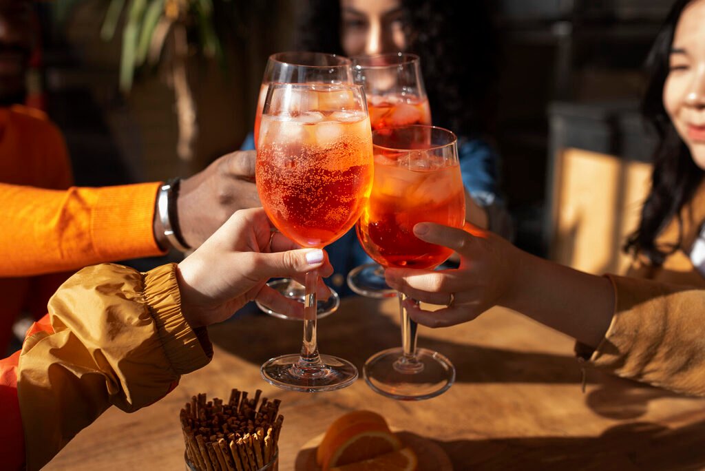 Copos com sucos naturais, refrigerantes e drinks coloridos servidos em um buffet de aniversário elegante.